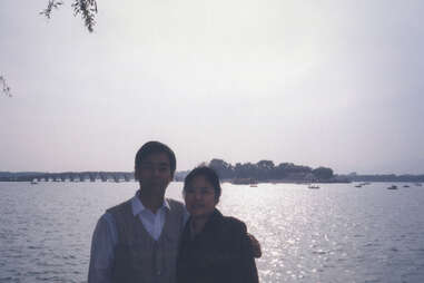 Couple poses in front of water for a vacation photo