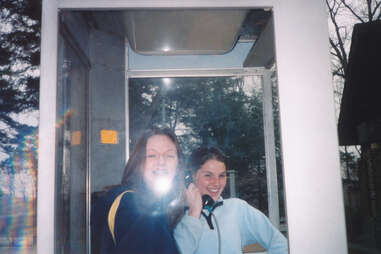 Teenagers having fun goofing around in phone booth 1990s travel photo