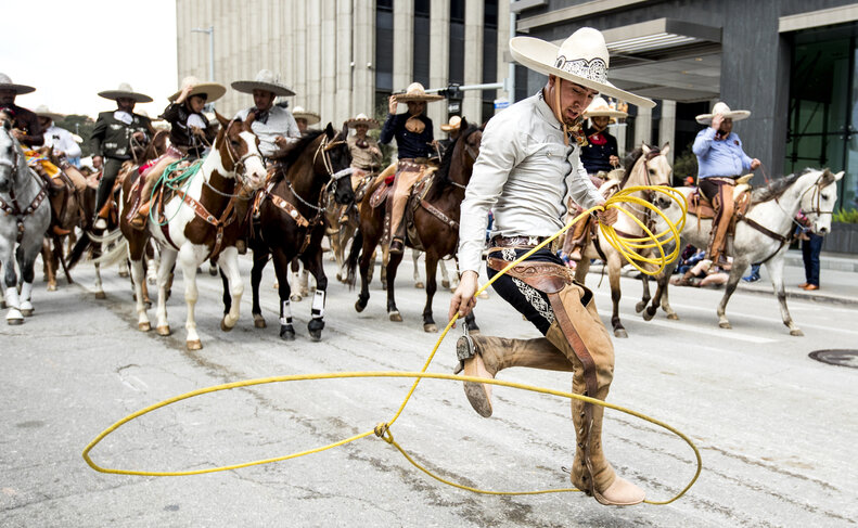 A man in a sombrero doing roping tricks