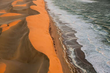 The point of the Atlantic ocean meeting the Namib Desert in Namibia. 