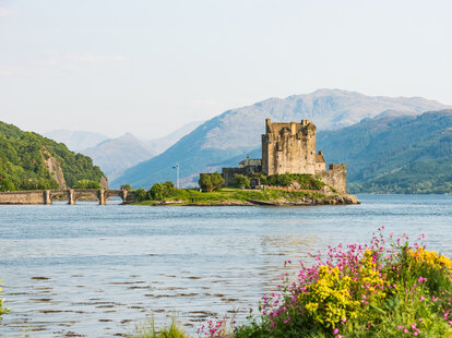 Eilean Donan Castle picture form the distance with sunset light at spring time.