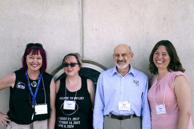 four solar eclipse task force members standing against a wall