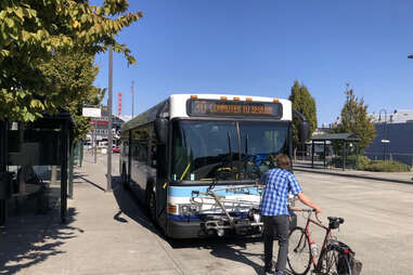 Strait Shot bus on road with man loading bike onto it in seattle washington