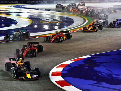 Sergio Perez of Mexico driving the (11) Oracle Red Bull Racing RB18 leads Charles Leclerc of Monaco driving the (16) Ferrari F1-75 and the rest of the field at the start during the F1 Grand Prix of Singapore.