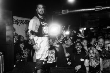 wrestler standing on the bar with an intense crowd at barroom blitz in la