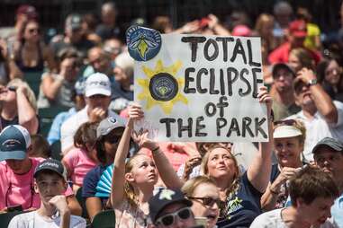 People gather at Spirit Communications Park to watch minor league baseball and a total solar eclipse