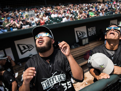 Minor league baseball player Jose Medina looks to the sun during a solar eclipse at Spirit Communications Park August 21, 2017 in Columbia, South Carolina