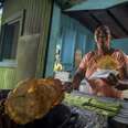 pork highway, chinchorreo, woman holding fried food next to plantains