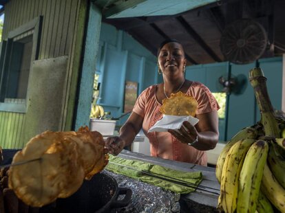 pork highway, chinchorreo, woman holding fried food next to plantains