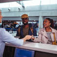 Young African-American couple doing check-in at airline check-in counter at international airport