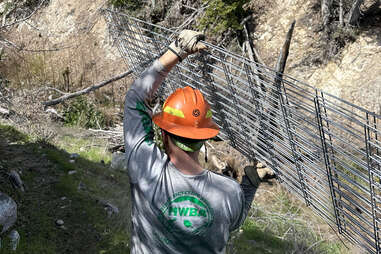 hiking trail worker carries metal in Angeles National Forest near LA 