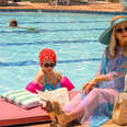 A still from the Apple TV+ miniseries 'Palm Royale' showing two characters sitting poolside. 