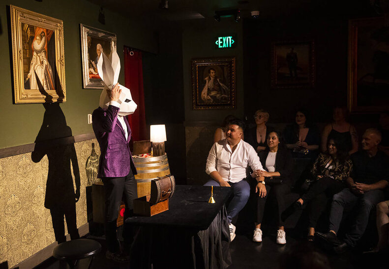 a man in a rabbit mask and fancy jacket talking to an audience