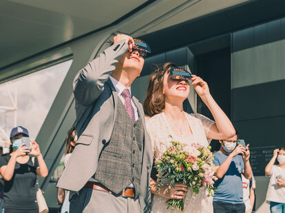 couple at wedding with eclipse glasses