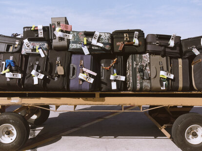 Suitcases on a luggage cart at the airport.