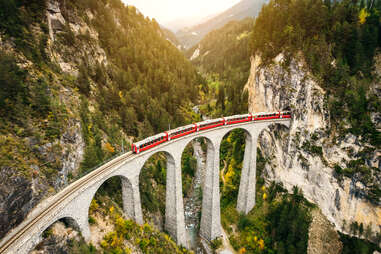 train on high bridge going through a mountain