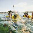 Medium shot portrait of smiling family on snorkeling tour in tropical ocean while on vacation.