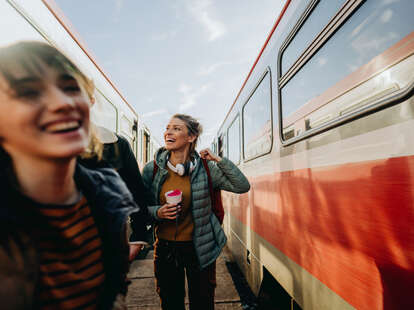 Photo of young women waiting for train together on a train station.