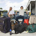 Two men with luggage sitting in airport area