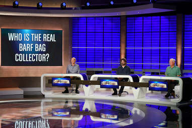 a panel of men on a game show with a screen that says Who is the Real Barf Bag Collector