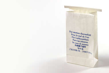 A white airsickness bag with "For Motion Sickness" written in many languages