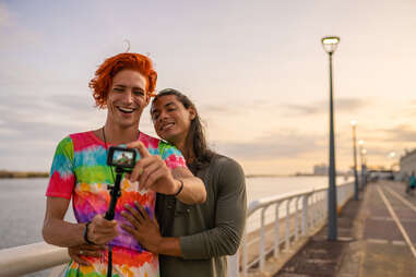 A gay couple taking photo in together on vacation.