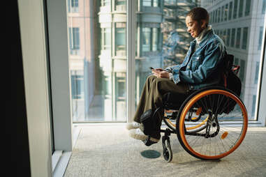 Young person in wheelchair looking at mobile phone