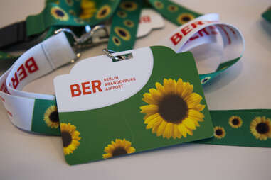 A "Sunflower" card with lanyard lies on a table at a press briefing at BER airport