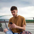 Portrait of young gay man with mobile phone