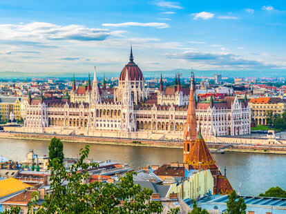 Hungarian Parliament on Danube river in Budapest at sunset during the summer.