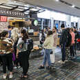 Long line of people waiting for coffee at airport Starbucks. 