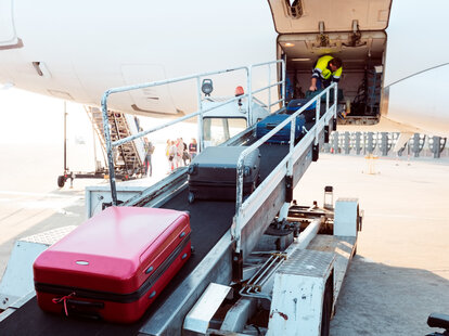 unloading luggage from a plane