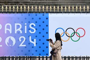 A bystander takes an image of a banner of the forthcoming Paris 2024 Olympic Games outside The National Assembly