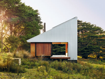 An Airbnb vacation rental in a field during golden hour.