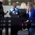 A Transportation Security Administration (TSA) officer checks a passenger's identification at a security checkpoint.