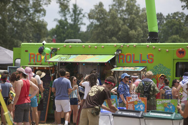 Food trucks at the Bonnaroo Music Festival, with a crowd of people wearing festival clothing.