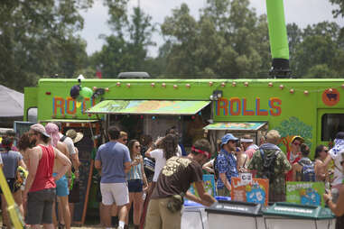 Food trucks at the Bonnaroo Music Festival, with a crowd of people wearing festival clothing. 