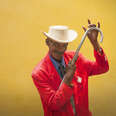 cuban male dancer in red suit posing with a cane on yellow background