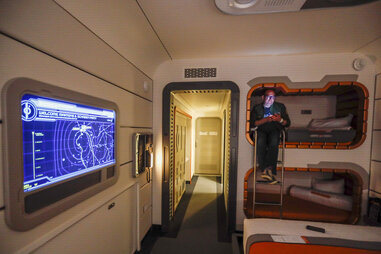 Los Angeles Times columnist Todd Martens sits in one of the bunk beds inside a room at the Halcyon ship