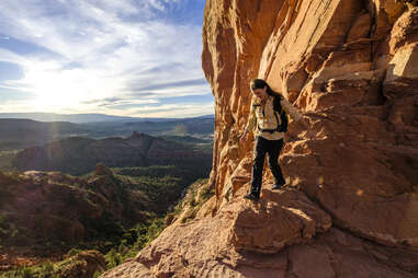 a woman walking on red rocks in Cathedral Rock Sedona