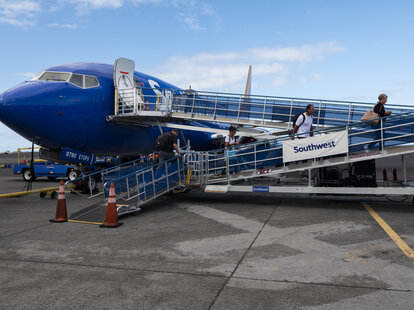 Passengers walk to board a Southwest Airlines jet at Ellison Onizuka Kona International Airport at Kehole on January 20, 2024 in Kailua-Kona, Hawaii.