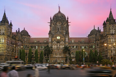 Chhatrapati Shivaji Terminus in Mumbai, India with pedestrians in foreground