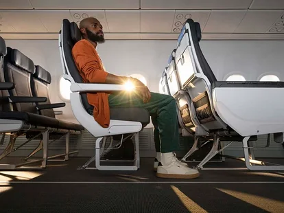 A man sitting in Premium Class seating on an Alaska Airlines flight.