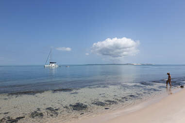 Young female walks along the beach in Benguerra Island, Mozambique