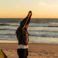 Young man stretching and camping on the beach in the early morning. 