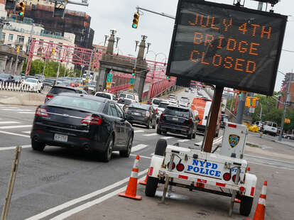 A sign notifies travelers that the bridge will close on July 4th at the Williamsburg Bridge in New York