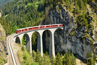 train on high bridge in Switzerland going through a mountain