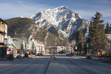 main street of a mountain town with a snow-capped peak