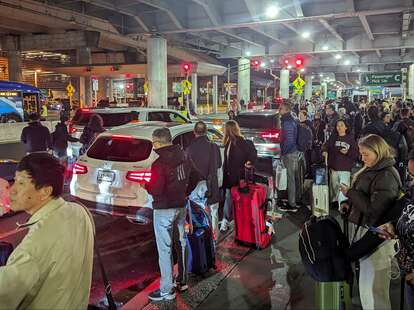 People waiting for rideshare transportation at JFK Airport