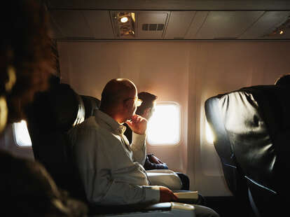 Businessmen on flight watching sunset out of airplane window rawdogging flight trend tiktok